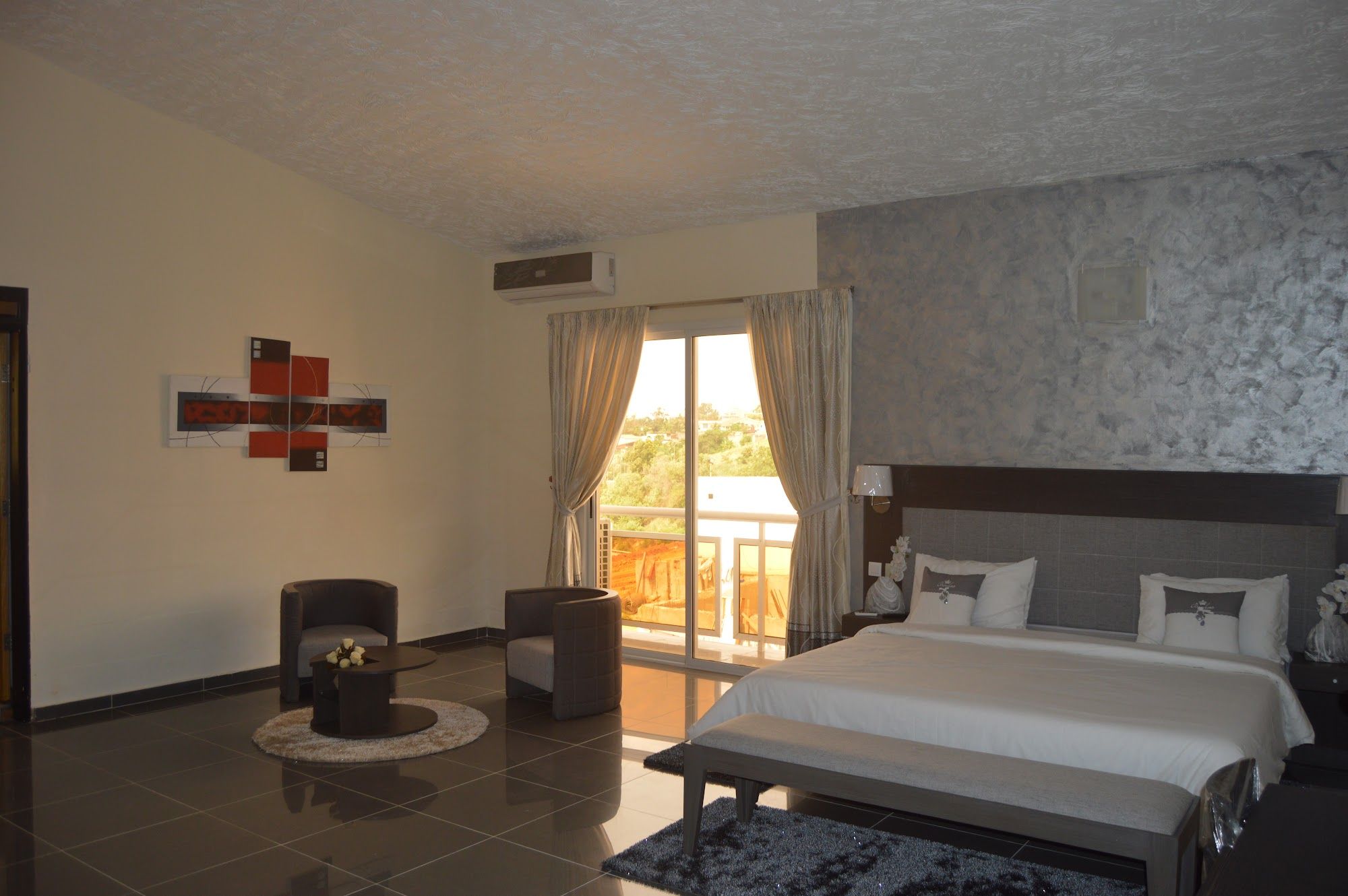 Grande chambre lumineuse avec coin salon et porte-fenêtre