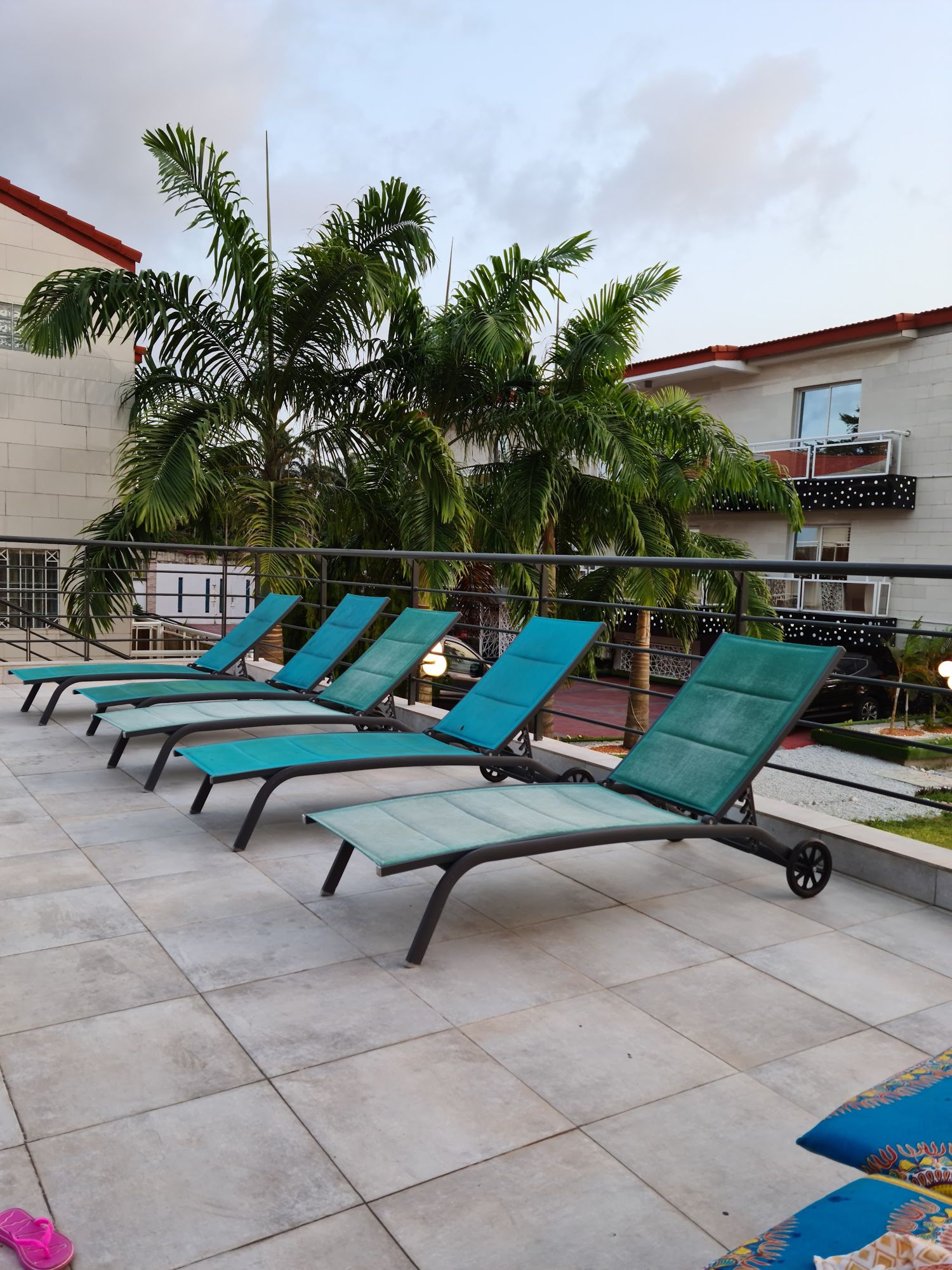 Transats turquoise sur la terrasse, sous les palmiers